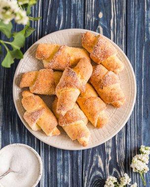 Mavi ahşap arka planda ev yapımı süzme peynirli mini kruvasan. Kruvasanla kahvaltı.