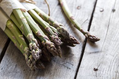 yeşil kuşkonmaz. Gri ahşap bir arka planda bir sürü yeşil kuşkonmaz