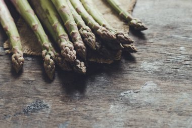 Yeşil kuşkonmaz. Koyu ahşap bir arka planda bir sürü yeşil kuşkonmaz.