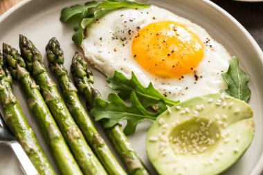 Kuşkonmaz, sahanda yumurta, avokado ve roka ile sağlıklı ev yapımı kahvaltı. Sağlıklı beslenme konseptini karantinaya alın. keto diyeti