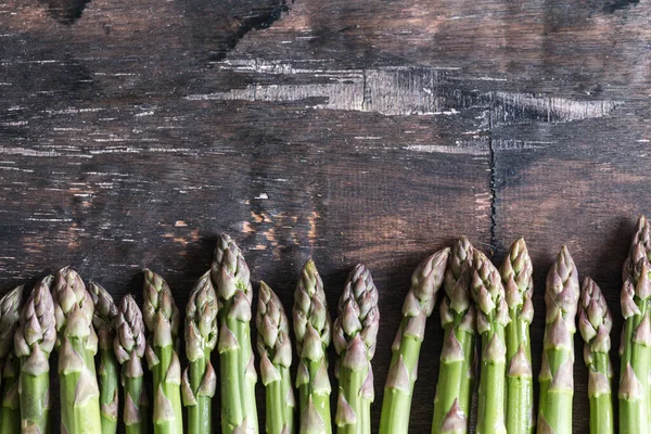 Green Asparagus. Bunches of green asparagus on a dark wooden rustic background