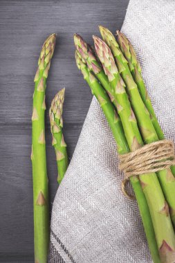 Kuşkonmaz. Ahşap masa üzerinde mutfak havlu ile ham kuşkonmaz