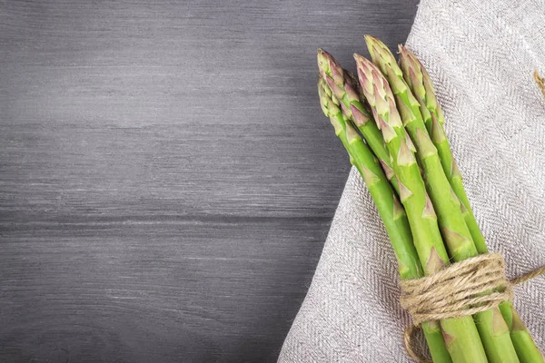 Ahşap bir arka planda bir sürü taze kuşkonmaz. Boşluğu kopyala