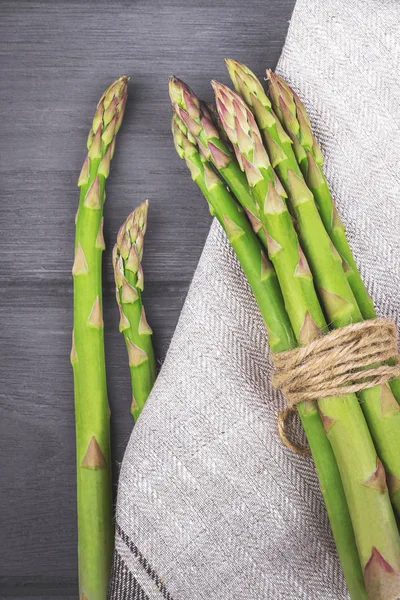 Kuşkonmaz. Ahşap masa üzerinde mutfak havlu ile ham kuşkonmaz