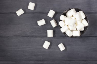 Kabarık beyaz hatmi kopya alanı ile siyah ahşap masa üzerinde yuvarlak kase.