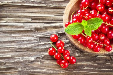 Bir ahşap plaka ahşap arka plan üzerinde kırmızı kuş üzümü. Kopya alanı ile Üstten Görünüm.