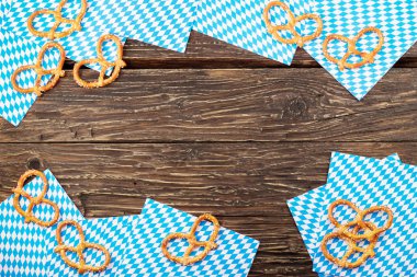 Ahşap masa üzerinde peçeteye tuzlu kraker. Bavyera oktoberfest simit. Kopya alanı ile Üstten Görünüm.