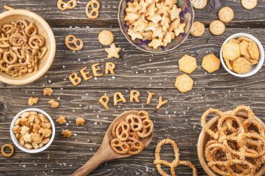 Yazıt bira ve parti kraker bir ahşap tahta üzerinde oluşur. Tuzlu atıştırmalıklar. Çubuk kraker, kraker.