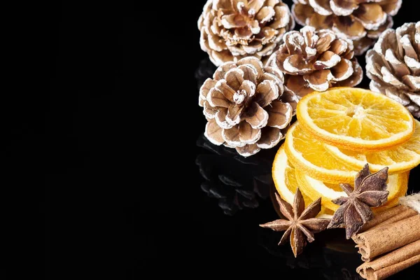Jul bakgrund med kottar, apelsin och kanel stick — Stockfoto