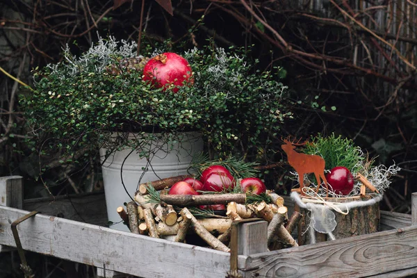 Decorazione natalizia con mele rosse invernali e melograno in scatola di legno Foto Stock Royalty Free
