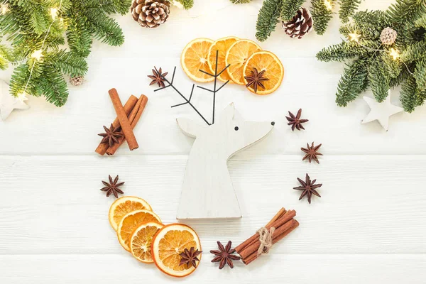 Christmas sammansättning på en vit bakgrund av juldekorationer. Trädgrenar, kottar, kanelstänger, stjärnanis, torkade apelsiner. Ovanifrån, platt låg — Stockfoto