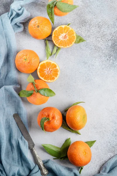 Mandarini arancioni freschi con foglie verdi con un coltello. Vista dall'alto Foto Stock