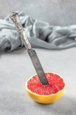 Taş masanın üzerine Pembe greyfurt narenciye meyve olgun yarısı. Greyfurt bıçakla dilim