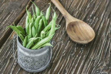 Taze yeşil fasulye ve kaşık ahşap arka plan üzerinde bölümünü