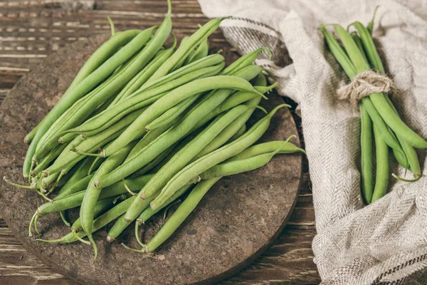 Fresh organic green beans on a rustic wooden  table top view.