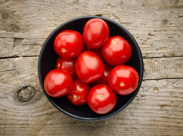 Cuenco de tomates sobre fondo de madera, desde arriba — Foto de Stock
