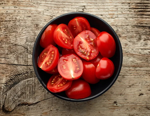 Cuenco de tomates sobre fondo de madera, desde arriba — Foto de Stock