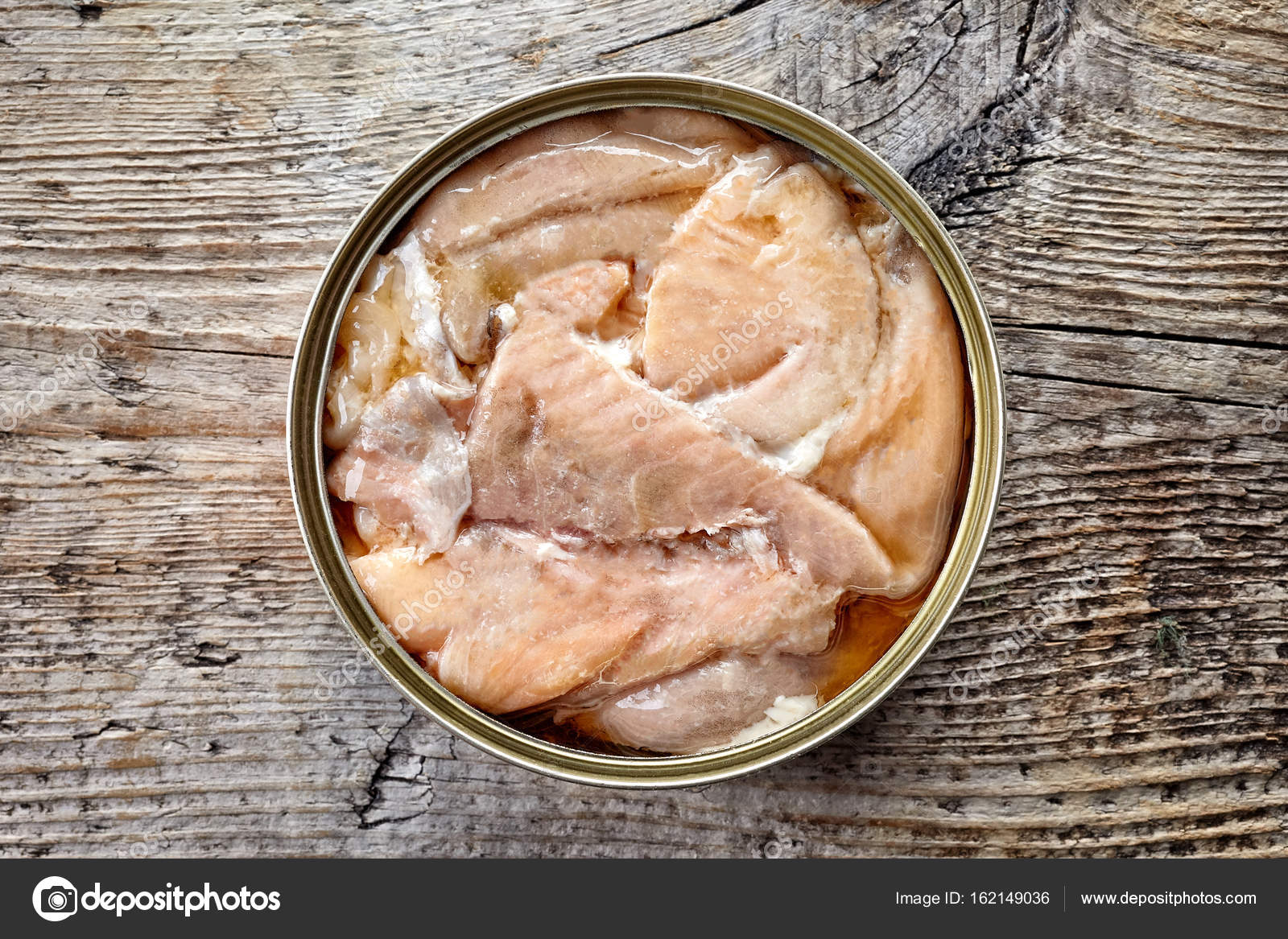 Canned salmon on wood, from above Stock Photo by