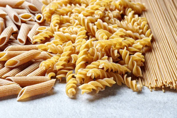 Various types of pasta on stone table — Stock Photo, Image