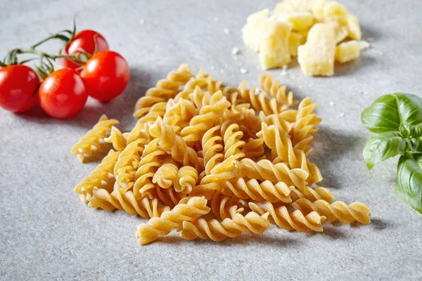 Pasta de espaguetis, queso y verduras sobre una mesa de piedra gris — Foto de Stock