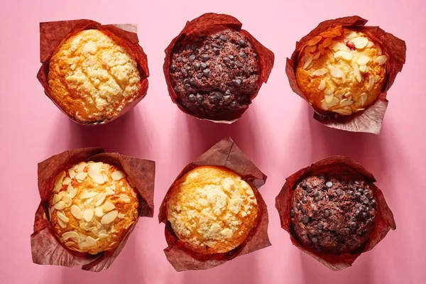 Muffins sobre fondo rosa, desde arriba —  Fotos de Stock