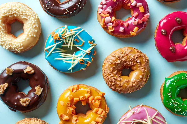 Vários donuts em fundo azul, de cima — Fotografia de Stock