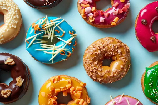 Vários donuts em fundo azul, de cima — Fotografia de Stock