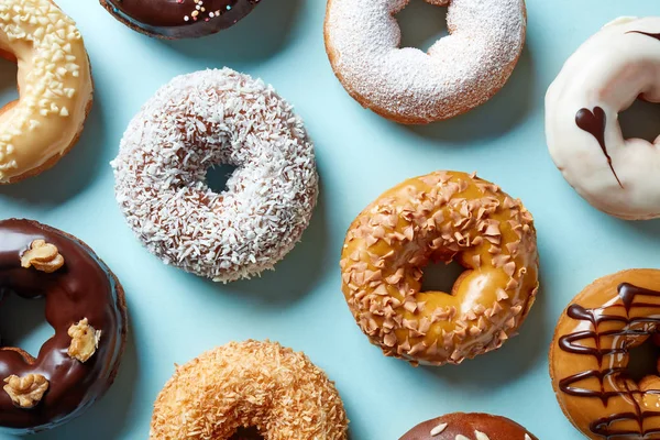 Vários donuts em fundo azul, de cima — Fotografia de Stock