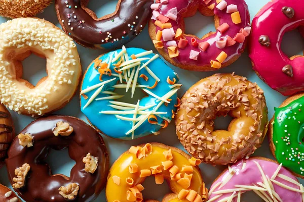 Vários donuts em fundo azul, de cima — Fotografia de Stock