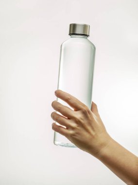 Beyaz arka planda izole edilmiş içme suyu olan yeniden kullanılabilir cam şişe.