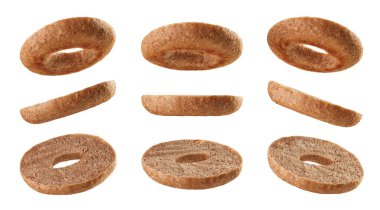 Yarım simit tabanları beyaz arka planda izole edilmiş farklı pozisyonlarda havada asılı duruyor.