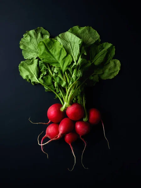 Bunch of fresh red radish on black background, top view