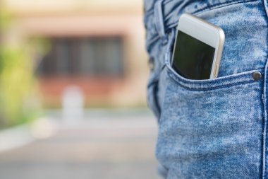 Kız kot pantolon cebinde akıllı telefon