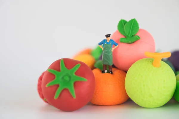 Sebze ve meyve, model ve küçük rakamlar üzerinde ayakta bakkal sahibi.