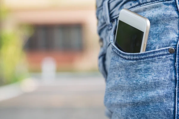 Smart phone in pocket of girl\'s jeans