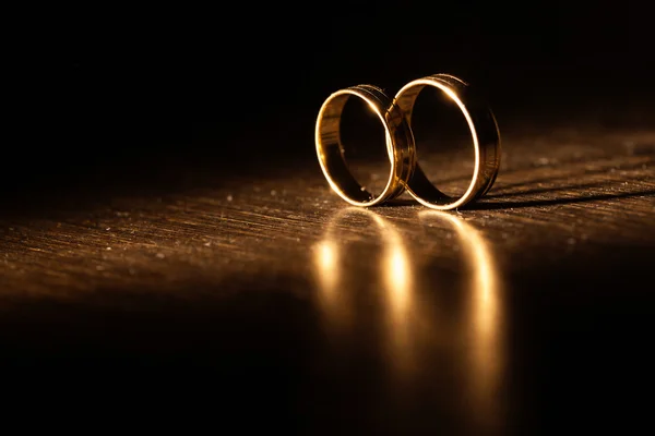 Wedding rings in rays of light with a beautiful shadow — Stockfoto
