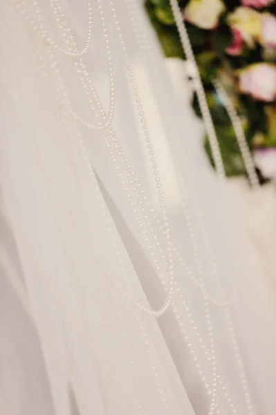 Perles de perles sur un arc de cérémonie de mariage avec un fond blanc — Photo