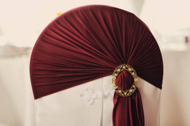 Beyaz şenlikli sandalyeler, arka planda Bordo düğüm