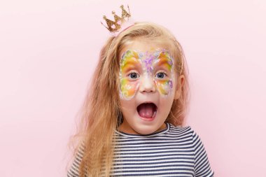 Pembe arka planda parlak bir yüz resmi olan, 3 yaşında, güzel, gülümseyen, küçük bir kız çocuğu. Eğlenceli duygular, mutlu çocukluk