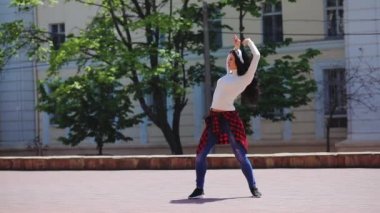 Kalça danslarında siyah ve kırmızı tişörtlü güzel bir kadın.