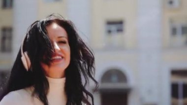 Güneşli bir günde, gülümseyen esmer kız profesyonel olarak dans ediyor.