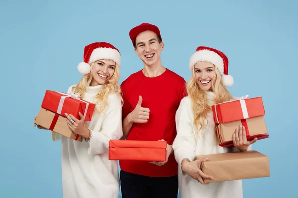 전달입니다 유니폼을 쿠리어는 모자를 쌍둥이 여성에게 크리스마스 선물을 전달했다 상자를 — 스톡 사진