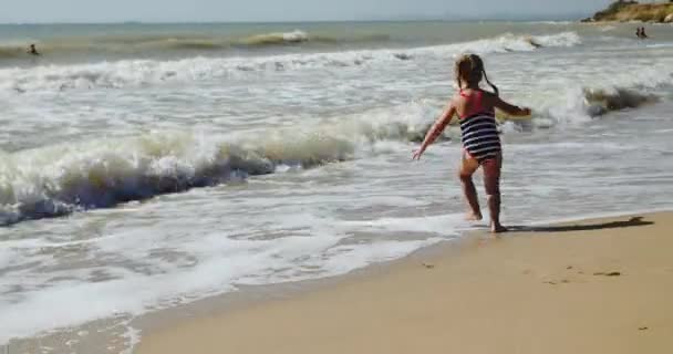 Piccola ragazza che indossa costume da bagno a righe celebra il Natale — Video Stock