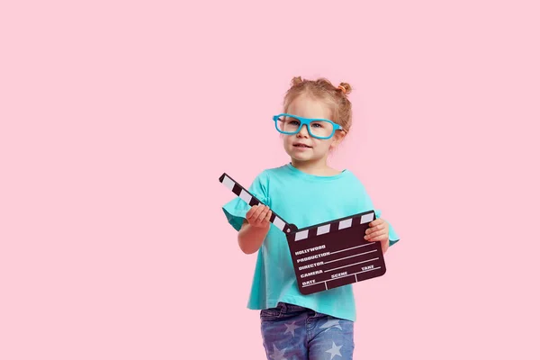 Śmiesznie Uśmiechnięta Dziewczynka Okularach Kinowych Trzyma Film Robiąc Klapki Różowym — Zdjęcie stockowe
