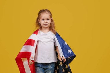 Vatansever bayram. Mutlu çocuk, sarı stüdyo geçmişinde Amerikan bayrağı olan sevimli küçük kız. Usa 4 Temmuz 'u kutluyor, Bağımsızlık Günü.