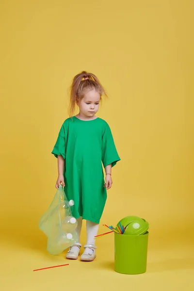 環境への配慮 小さな女の子はリサイクルする別のプラスチックごみです 明るいカラースタジオの背景 — ストック写真