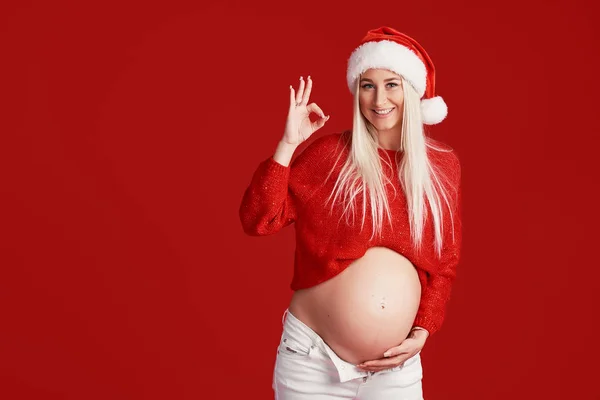 Tânără Însărcinată Pălărie Moş Crăciun Fundal Roşu Fată Veselă Aşteptată — Fotografie, imagine de stoc