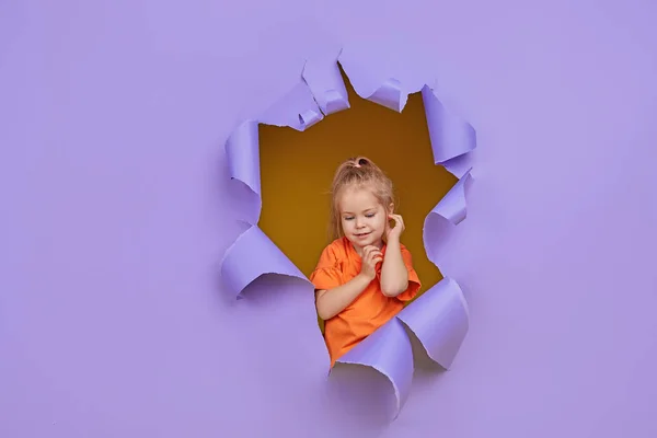 Cute Little Child Girl Breaks Colored Purple Paper Wall Toddler — Stock Photo, Image