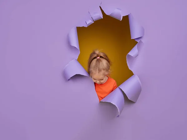 Carino Bambina Rompe Attraverso Muro Carta Viola Colorato Faccia Emozioni — Foto Stock