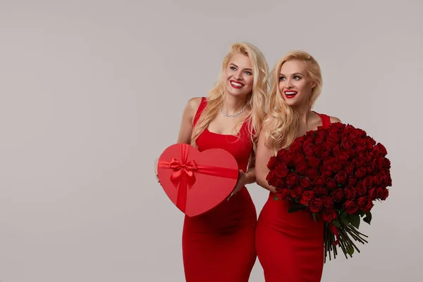 Dwie Szczęśliwe Młode Bliźniaczki Dużym Bukietem Czerwonych Róż Czerwonym Pudełkiem — Zdjęcie stockowe